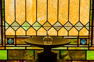 chalice in front of stained glass window